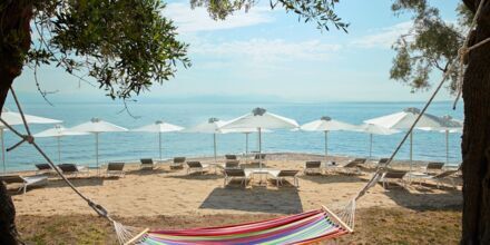 Stranden vid hotell MarBella Nido Suite Hotel & Villa i Agios Ioannis Peristeron på Korfu, Grekland.