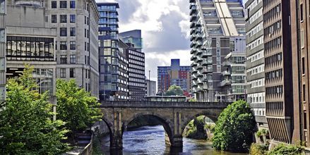 Floden Irwell som rinner genom Manchester kantas av moderna lägenheter.